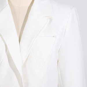 Détail du col à revers et de la couture d'épaule d'un blazer cintré blanc pour femme
