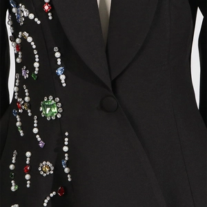 Close-up of colored crystals and pearls embellishments on a black tailored blazer jacket