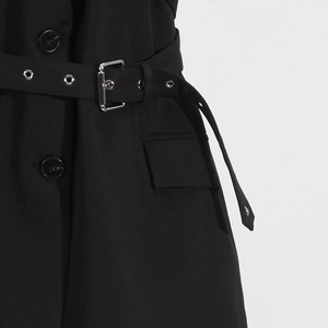 Close-up of black sleeveless blazer with adjustable waist belt and silver metal buckle