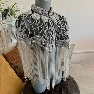 Close-up of black mesh shawl with silver bead embroidery and beaded fringe detail