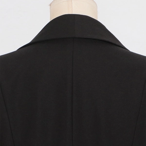 Close-up of the tailored lapel and high-density black fabric on the fitted blazer