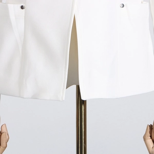 Détail de la fente arrière et de la boucle décorative en métal du blazer blanc