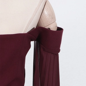 Close-up of elegant burgundy off-shoulder sleeve detail with pleated chiffon splicing