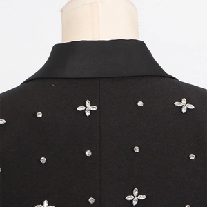 Close-up of sparkling floral rhinestones on a premium black tailored blazer jacket