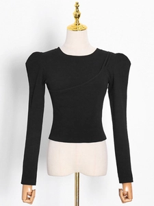 Slim fit long sleeve knit top in black with puff shoulders and asymmetric seam detail