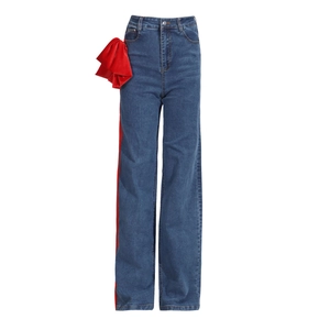 Detail of high waist denim jeans featuring red velvet ruffles and side stripe contrast