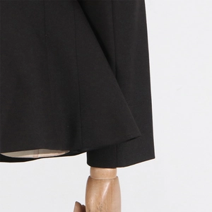 Close-up of the straight hem and cuff tailoring on this slim black blazer jacket