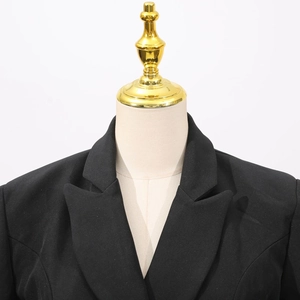 Détail d'un blazer noir cintré avec revers à encoche sur un mannequin de couture