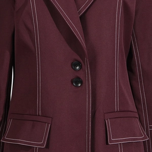 Detail der weinroten Blazerjacke mit weißen Kontrastnähten, Pattentaschen und Knöpfen