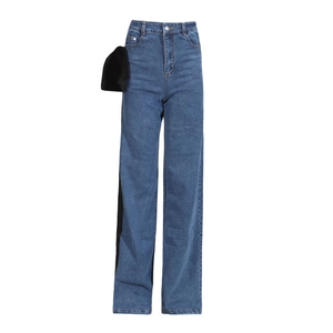 Detailed view of high waist denim jeans featuring a large decorative black bow on the side