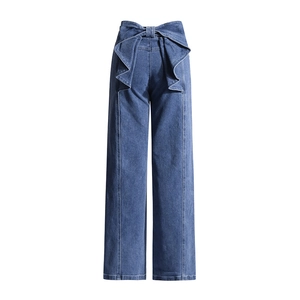 Détail d'un jean taille haute orné d'un grand nœud décoratif sur la taille à l'arrière