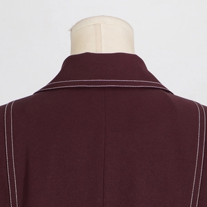 Detailansicht des dunkel weinroten Trenchcoat-Kragens mit weißen Kontrast-Doppelnähten