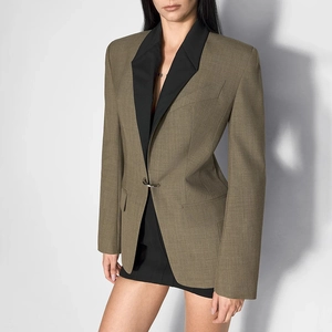 Detail of a khaki blazer with black peaked lapels and a single metallic ring button closure