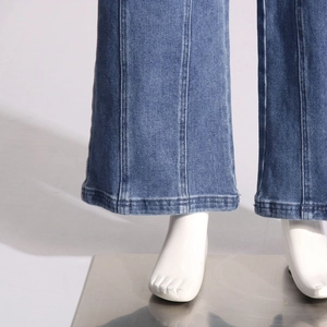 Détail du jean denim bleu délavé avec couture verticale frontale et coupe évasée