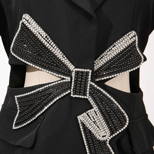 Détail d'un nœud perlé avec strass argentés sur une robe blazer noire de luxe