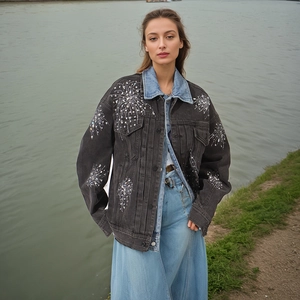 Vue détaillée des motifs de feux d'artifice en strass sur veste en jean gris foncé
