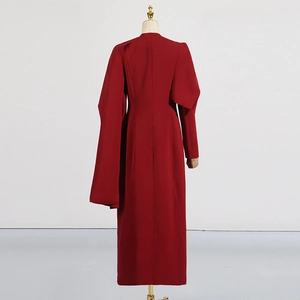 Vue détaillée du dos d'un trench-coat rouge foncé avec design cape asymétrique et manches longues