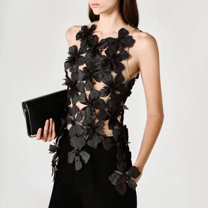 Detailed view of the 3D satin floral appliqués on a black mesh sleeveless top