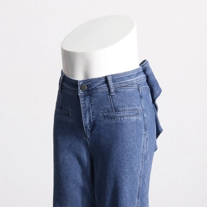 Détail du dos d'un jean bleu taille haute avec un nœud papillon élégant à la ceinture