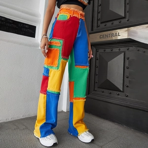 Macro detail of high-waisted wide-leg jeans featuring colorful patchwork and frayed edges
