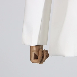 Close-up of white blazer sleeve detail featuring smooth woven fabric and clean stitching