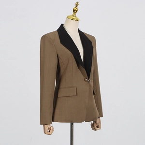 Close-up of contrast peaked lapel and silver metal button on tan suit jacket