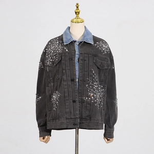 Détail de la veste en jean gris foncé avec strass étincelants et col bleu contrasté