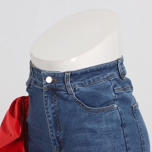 Detail of high waist blue jeans showing orange stitching and red silk waist decoration