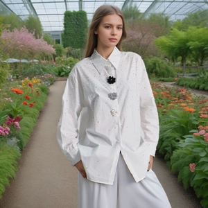Detail of white long sleeve shirt featuring three unique floral decorative buttons and rhinestones