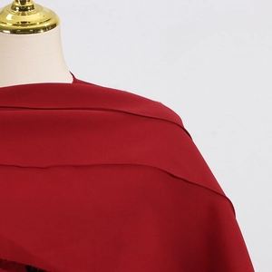 Vue détaillée de la texture du tissu en mousseline rouge foncé léger avec un drapé élégant