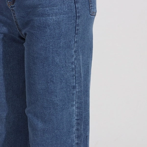Detailed close-up of blue denim texture featuring orange stitching and washed finish detail