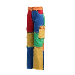 Close-up of vibrant patchwork denim jeans with distressed frayed edges and multi-color panels