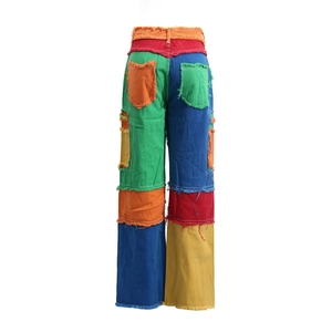 Detail view of multi-colored patchwork denim with raw-edge fringe and high-waist design