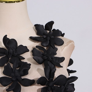 Detail of 3D black floral appliqué and mesh stitching on women sleeveless top