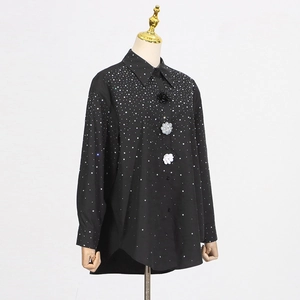 Macro shot of black rhinestone shirt featuring 3D floral buttons and sparkling crystals