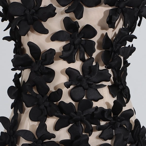 Detail of 3D black floral appliqué on sheer nude mesh fabric for a stylish summer top