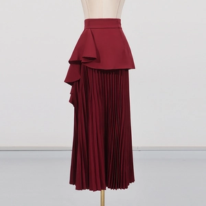 Détail d'une jupe longue plissée bordeaux avec taille à basque et volants élégants