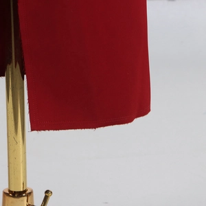Détail macro d'une double couture de qualité sur l'ourlet d'un manteau rouge foncé élégant