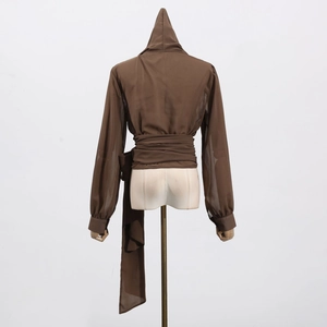 Detail of dark brown hooded blouse with semi-transparent fabric and wrap-around waist ties