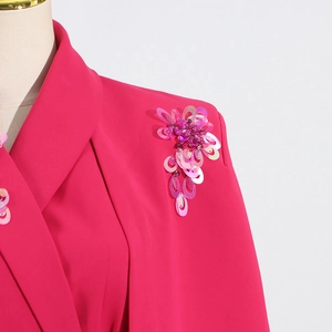 Detail of fuchsia blazer featuring handmade sequined floral shoulder tassel and beads