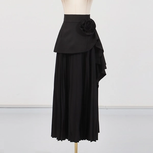 Détail d'une jupe plissée noire à taille haute avec une fleur 3D élégante à la taille