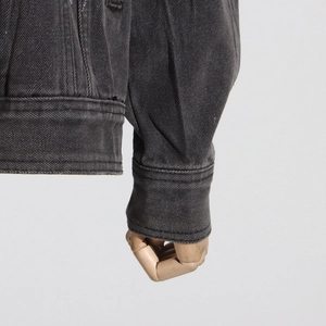 Détail du poignet d'une veste en jean gris foncé avec couture à une seule aiguille