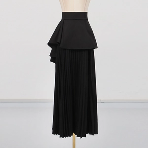 Détail d'une jupe longue plissée noire à taille haute avec volants irréguliers