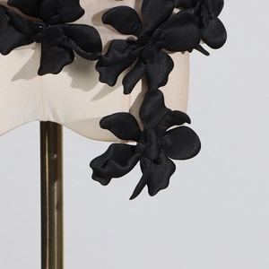 Close-up of 3D black satin flower applique on beige mesh sleeveless summer top