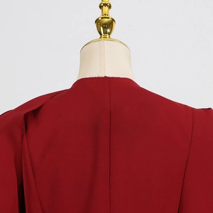 Détail arrière d'un trench-coat rouge foncé avec col à bords francs et coutures soignées