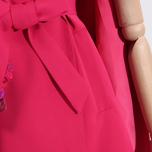 Close-up of hot pink blazer with large bow detail and teardrop sequin embellishments