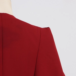 Détail d'un trench rouge pour femme montrant la couture d'épaule et la texture du tissu