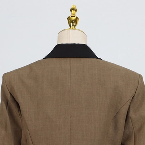 Detail of brown blazer back with black collar stitching and fine woven fabric texture
