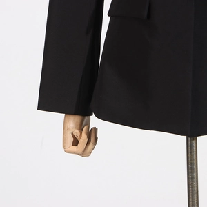 Detail of classic black blazer featuring flap pocket and premium woven fabric texture