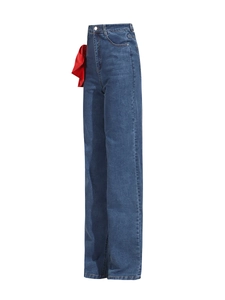 High-waisted wide-leg dark denim jeans with a large red satin bow on the waist accent